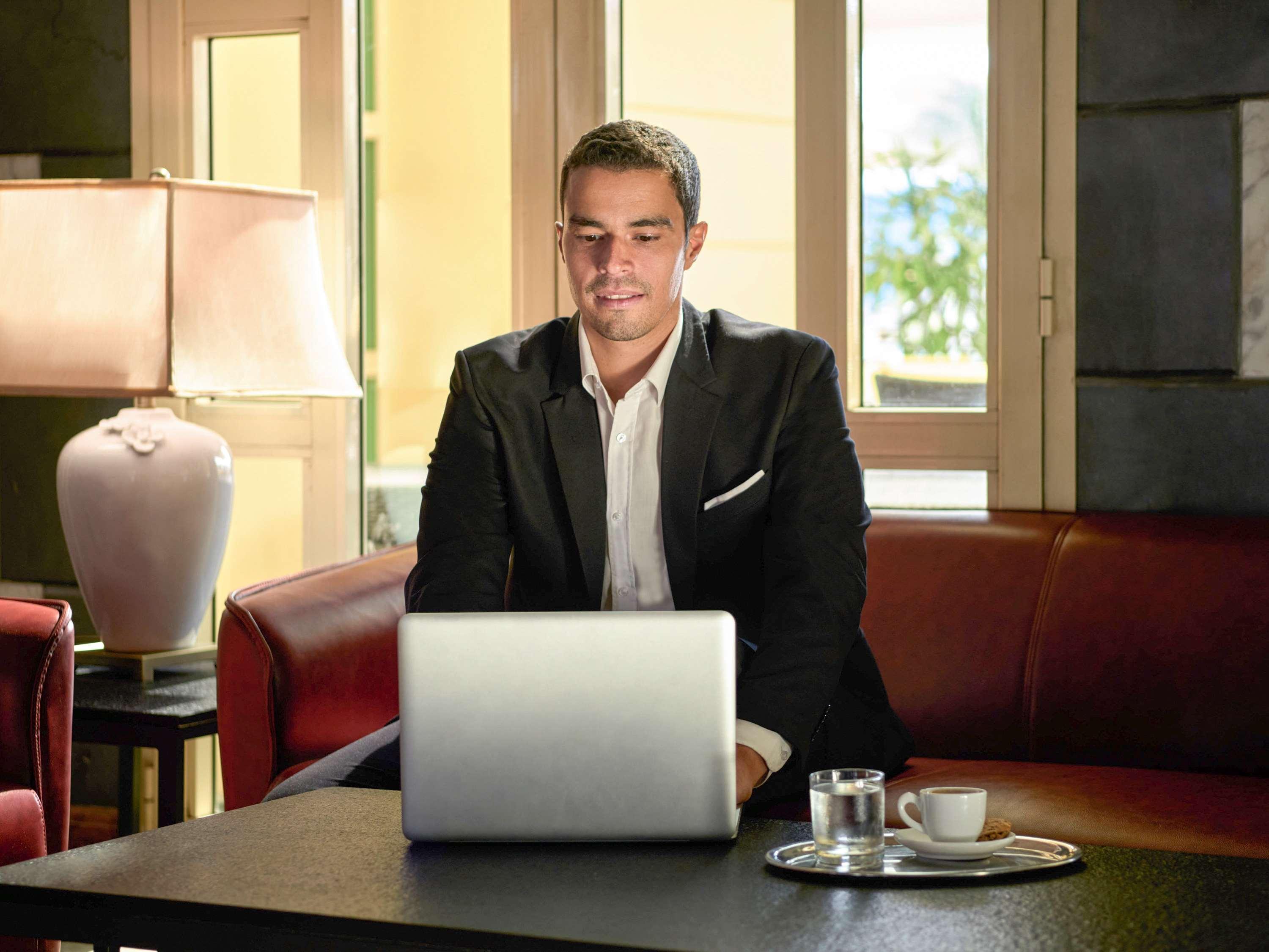 Moevenpick Hotel Cairo - Media City Giza Buitenkant foto A business traveller working on a laptop